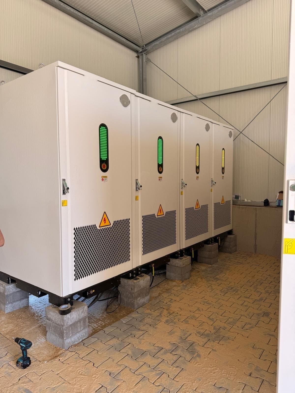 Battery cabinets with green charge indicators inside a hall