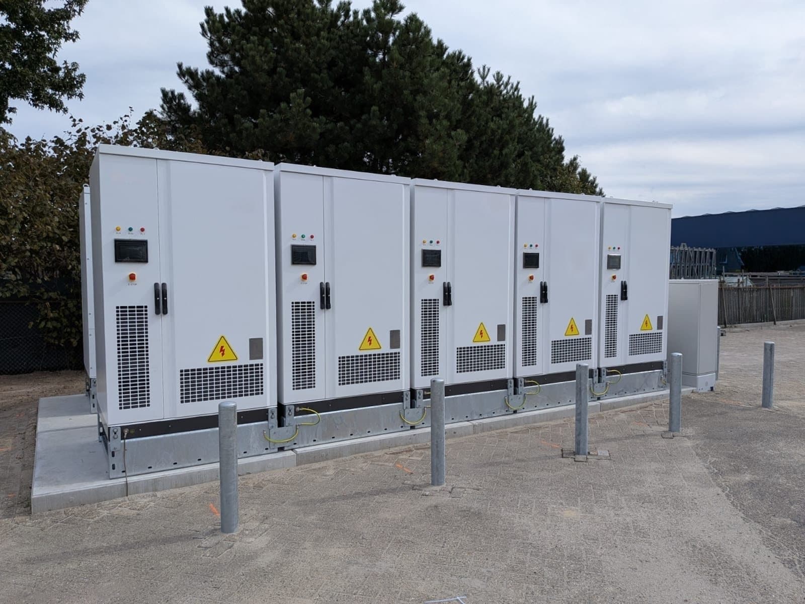A row of battery cabinets behind protection posts on a business site